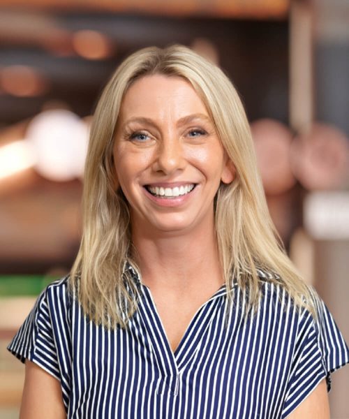 a woman in a striped shirt and smiling at the camera