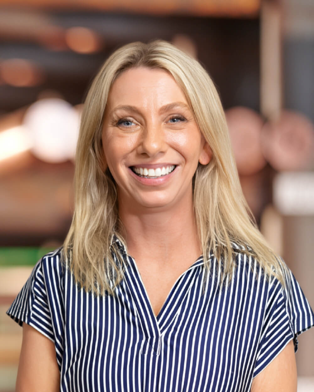 a woman in a striped shirt and smiling at the camera